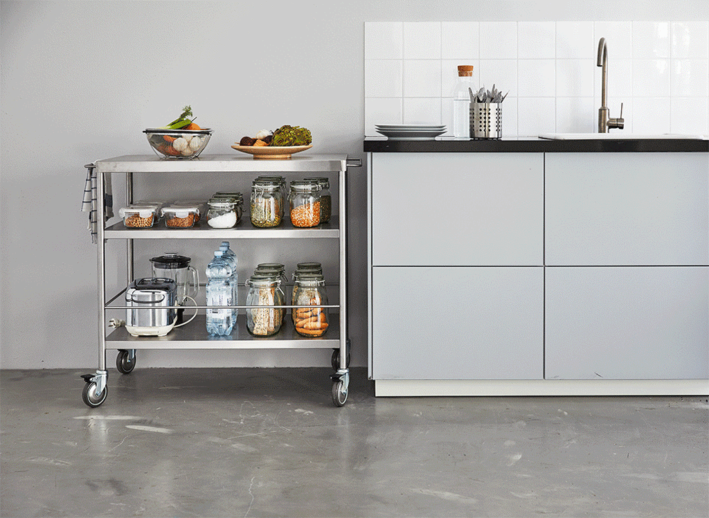 A GIF shows a metal kitchen islande moving from the centre of the room to its spot next to a kitchen counter.