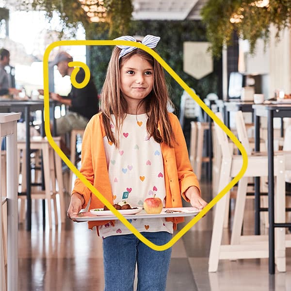 A girl carries a tray in a restaurant