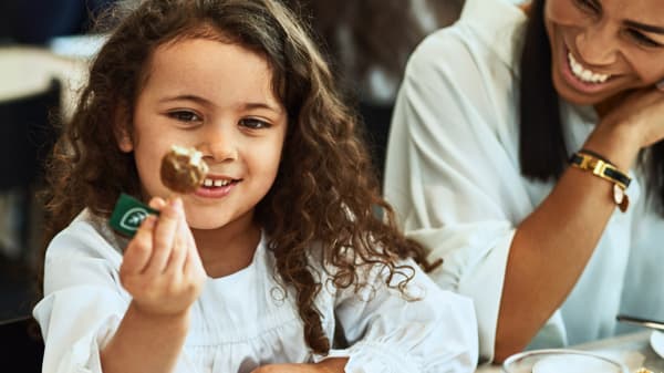 A girl is eating a meat-free patty in the IKEA restaurant