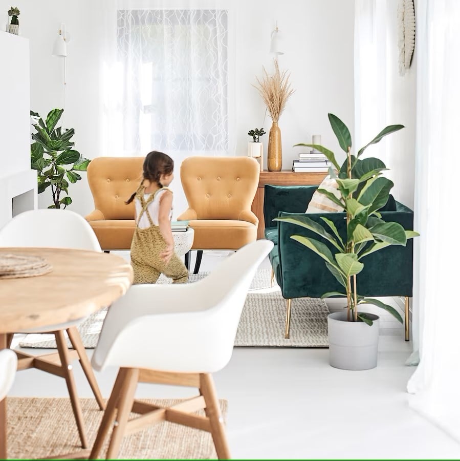 a-girl-runs-through-an-open-plan-dining-living-area-with-green-theme