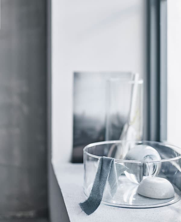 A glass vase in a windowsill with daylight shining in.
