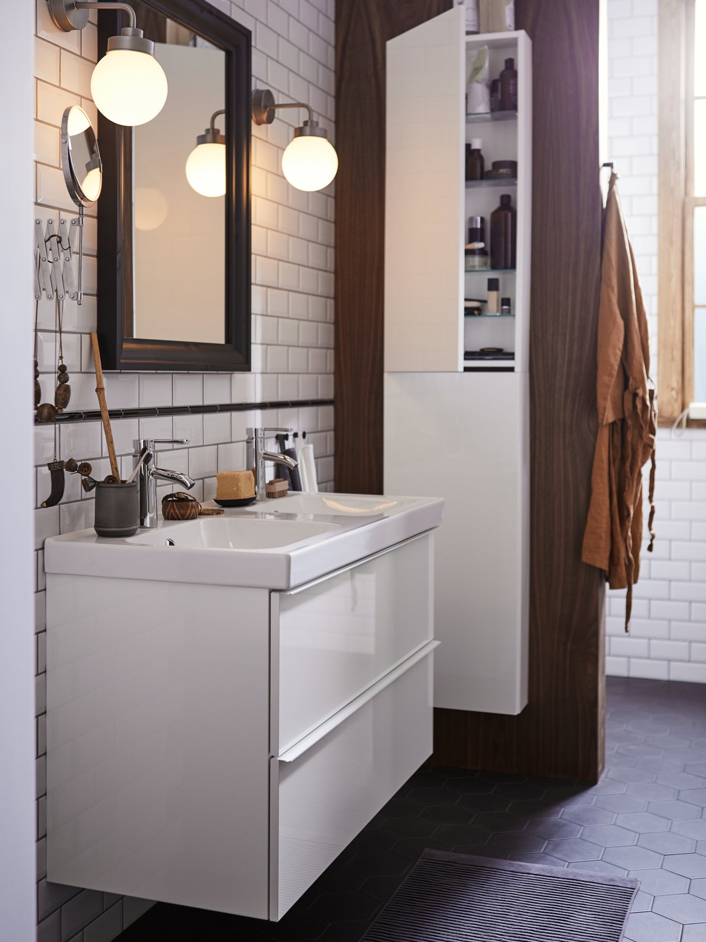 A GODMORGON bathroom with a two drawer wash-stand with a mirror above and an ajar high cabinet to the right, with toiletries.