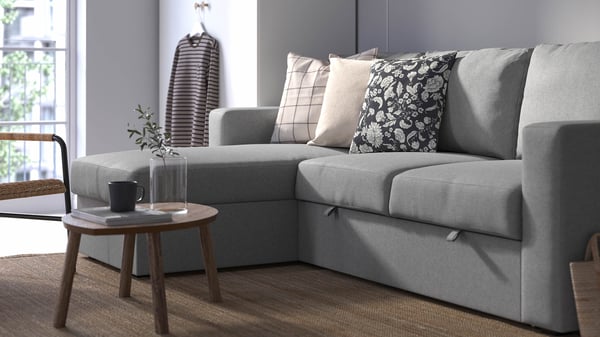 A gray  BÅRSLÖV sleeper sofa with a brown coffee table in front of it.