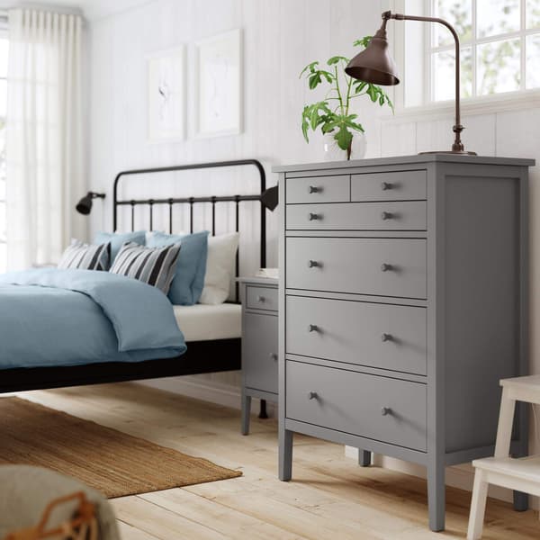 A gray dresser in a bedroom.