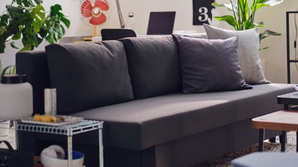 A gray sleeper sofa in a dorm room