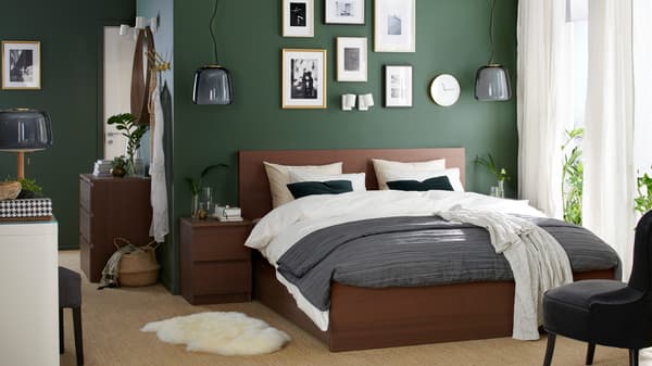A green bedroom featuring a MALM bed frame, bedside table and dressing table in black brown veneer.