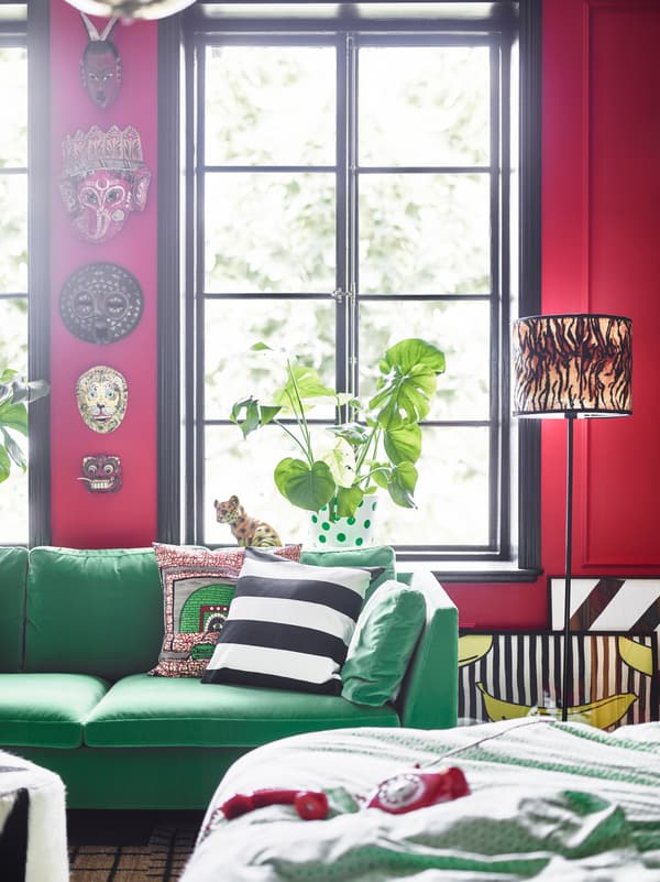 A green sofa and African masks on the wall help give this dream bedroom a bold look.