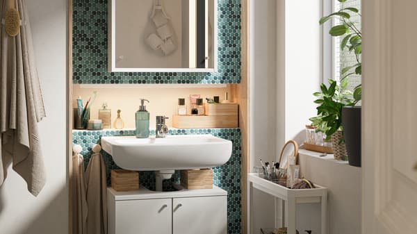 A green-tiled bathroom with a white bathroom furniture set, potted plants and white trolley with toiletries in it.
