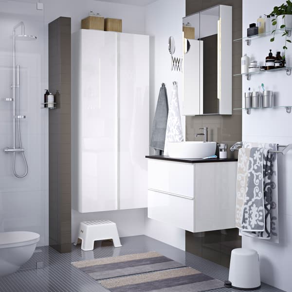 A grey and white bathroom with white washstand and cabinet.