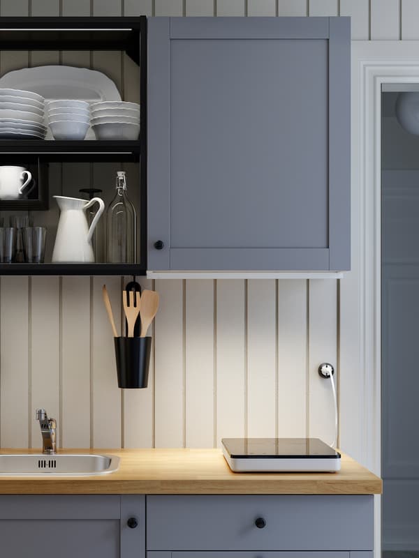 A grey/anthracite/wooden ENHET kitchen, a portable induction hob and LED lighting strips that illuminate the worktop.