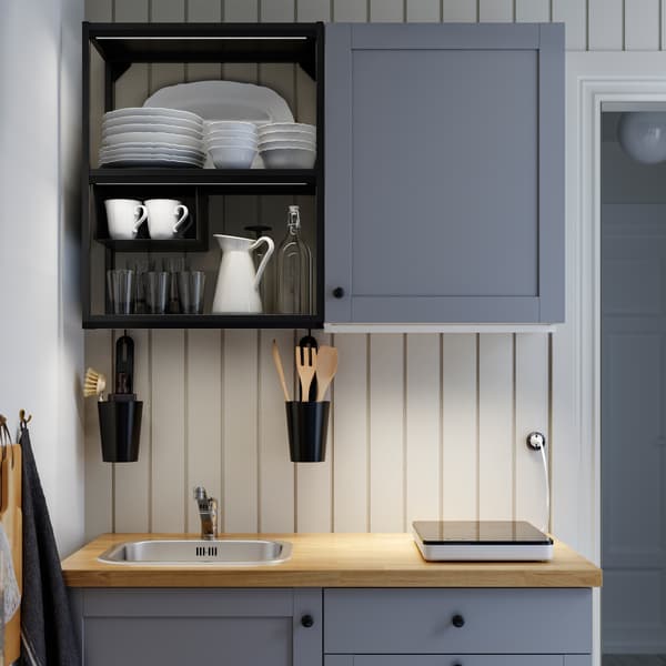 A grey/anthracite/wooden ENHET kitchen, a portable induction hob and LED lighting strips that illuminate the worktop.