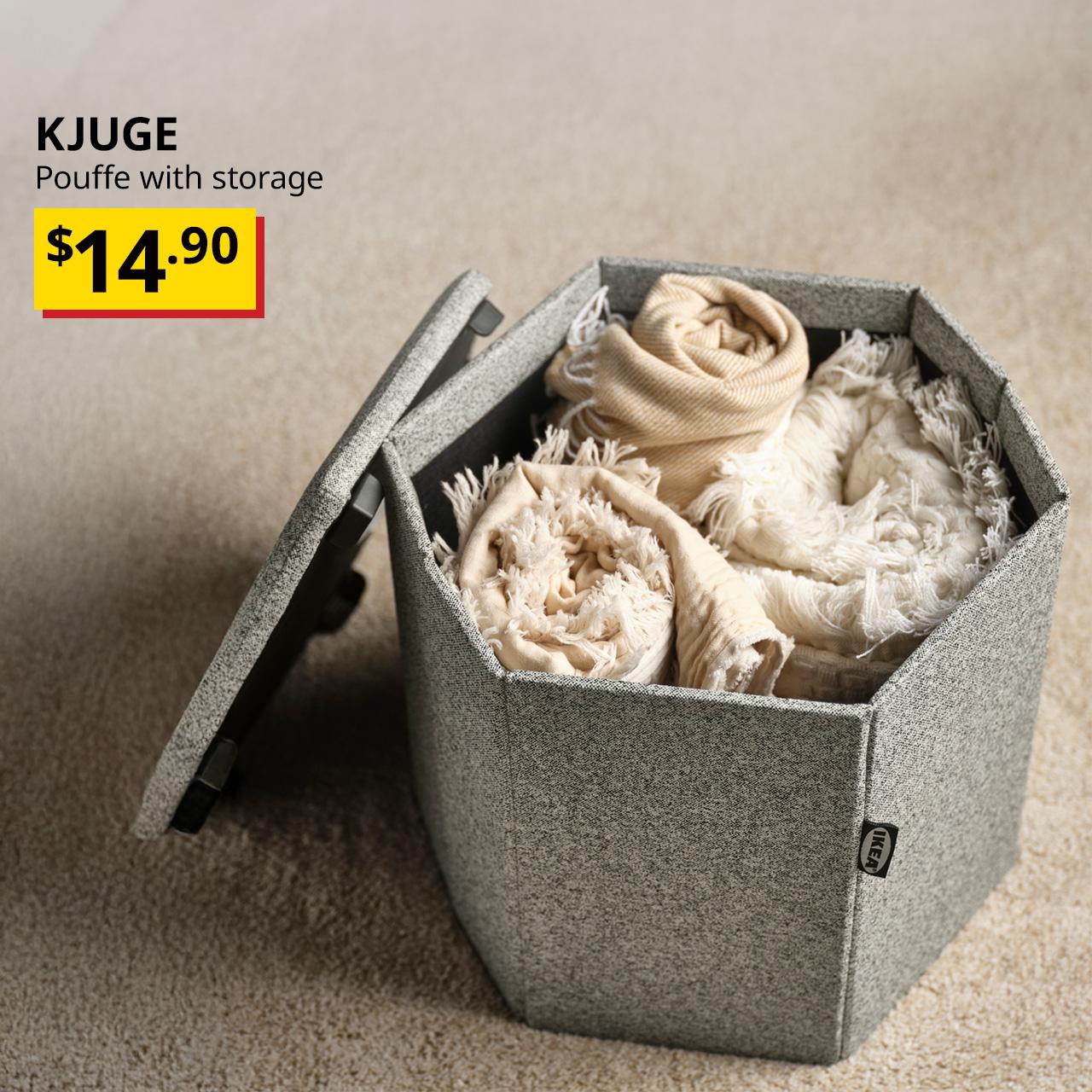 A grey-beige KJUGE pouffe with storage, shown with the cover tilted against it, demonstrating how the storage compartment can be used for storing throws. Black text overlay image on the left that reads, "KJUGE, Pouffe with Storage," with the BTI price in yellow/red and black text: $14.90.