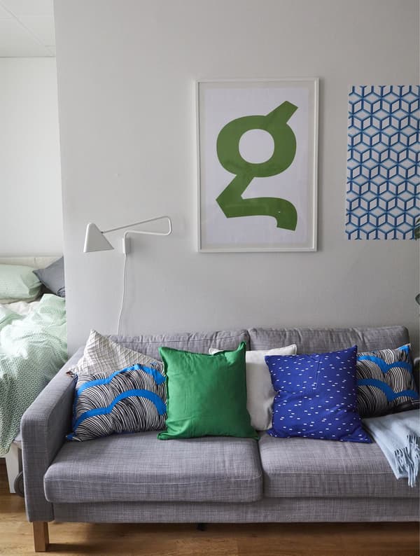A grey sofa with brightly coloured cushions.