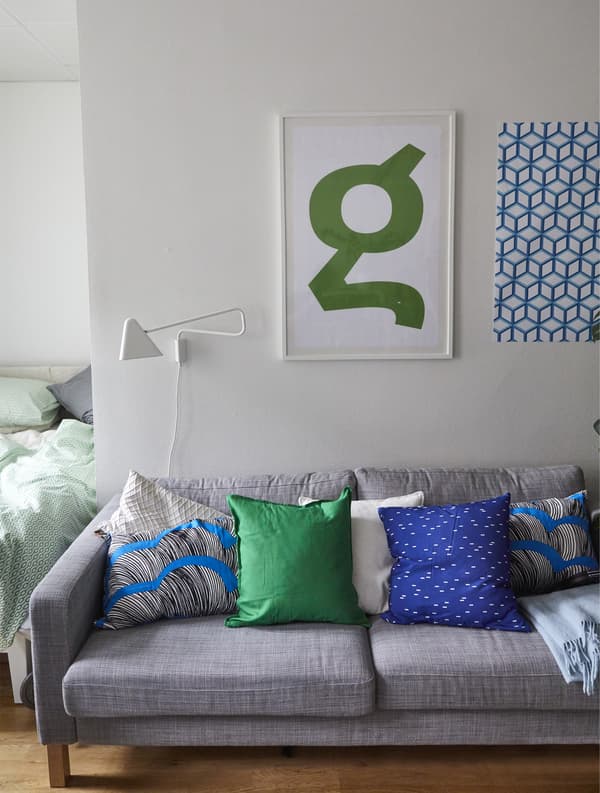 A grey sofa with brightly coloured cushions.