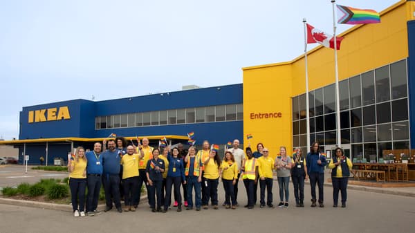 A group of co-workers are gathered outside an IKEA store.