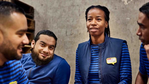 A group of IKEA co-workers wearing blue IKEA uniforms.