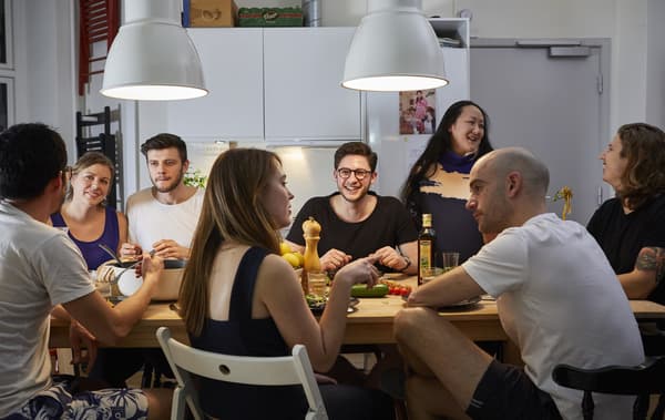 A group of people eating around a dinner table.