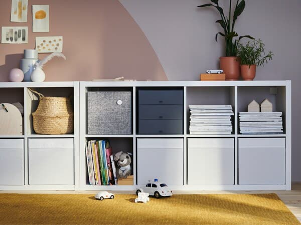 A half-height white KALLAX chest of drawers with open elements and inserts.
