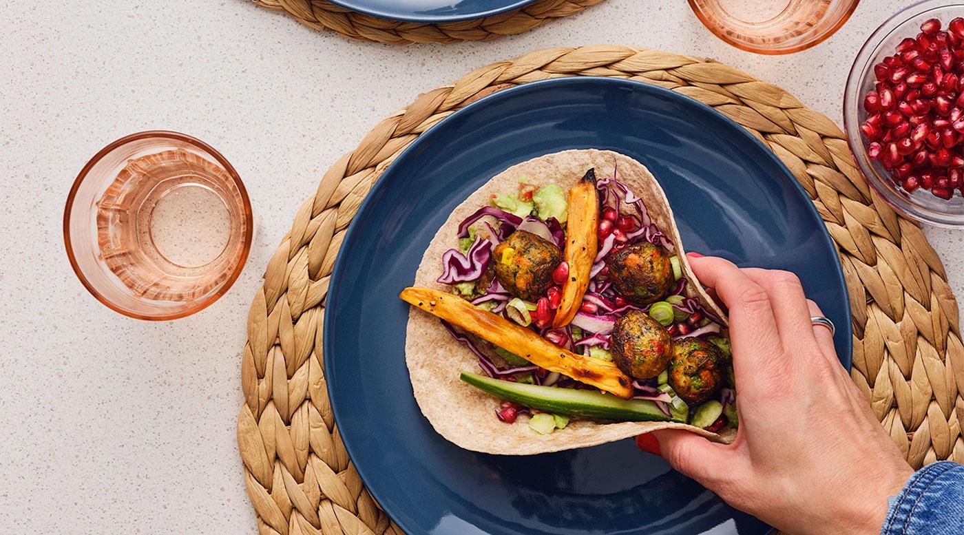 A hand holding a Veggie ball tortilla.