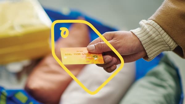 A hand is holding a credit card.