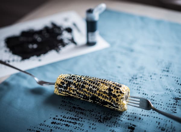 A handmade print on blue IKEA DITTE fabric, created by rolling a black painted corncob across the fabric.