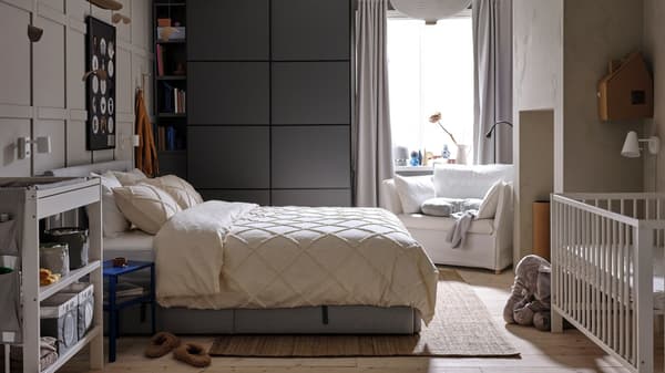 A hanging rail holds clothing and two SKUBB hanging storage with 6 compartments, with a GLANSHAGTORN curtain beside it.
