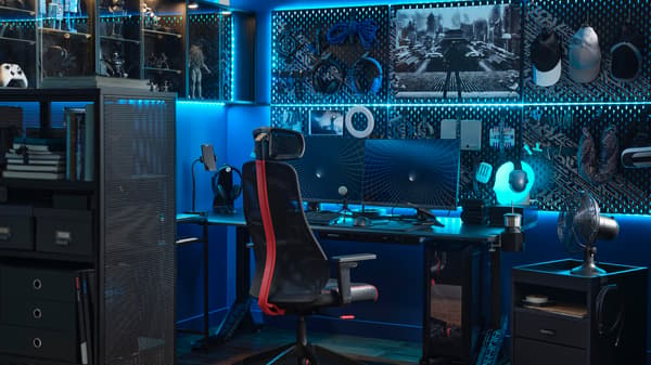 A high-tech gaming setup with blue LED lighting and two monitors on a desk with a black MATCHSPEL gaming chair in front.