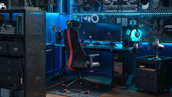 A high-tech gaming setup with blue LED lighting and two monitors on a desk with a black MATCHSPEL gaming chair in front.