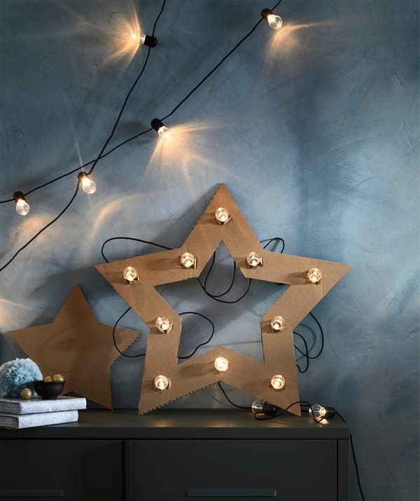 A home-made cardboard star decorated with an IKEA BLÖTSNÖ LED lighting chain.