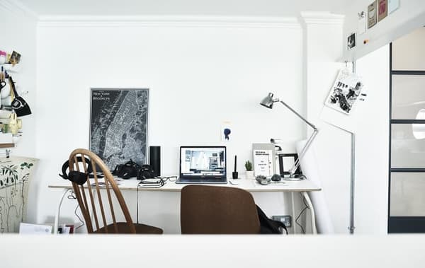 A home workspace with two chairs and white desk.