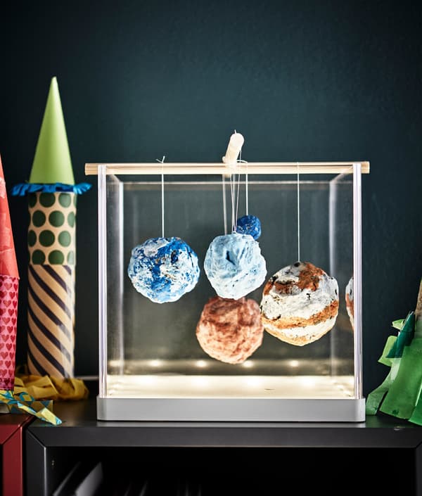 A homemade planetary system displayed in a light box with integrated lighting.