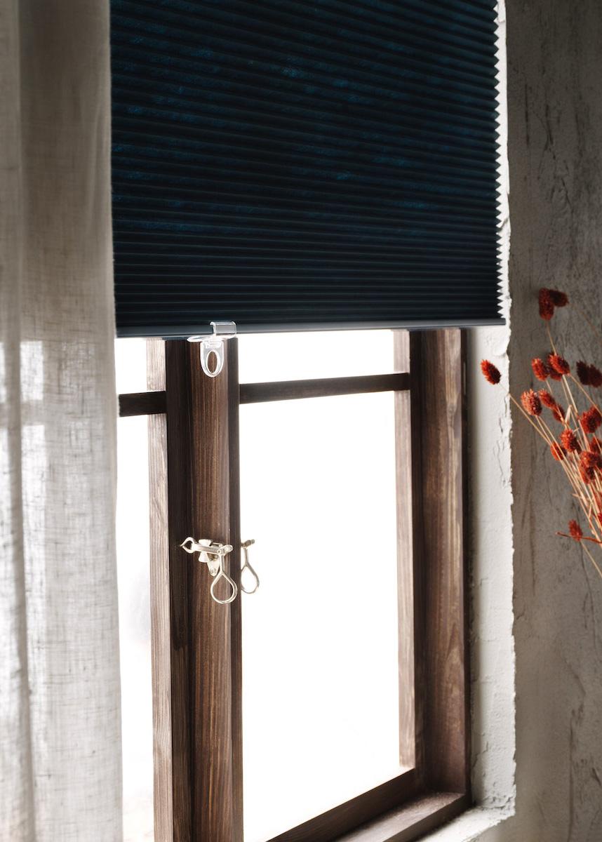 A HOPPVALS blind half shutting brightly lit window.