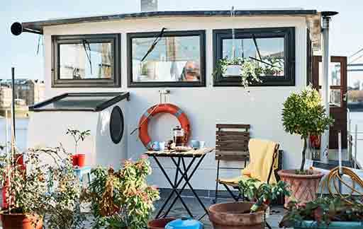 a-houseboat-deck-with-outdoor-table-and-foldable-chairs