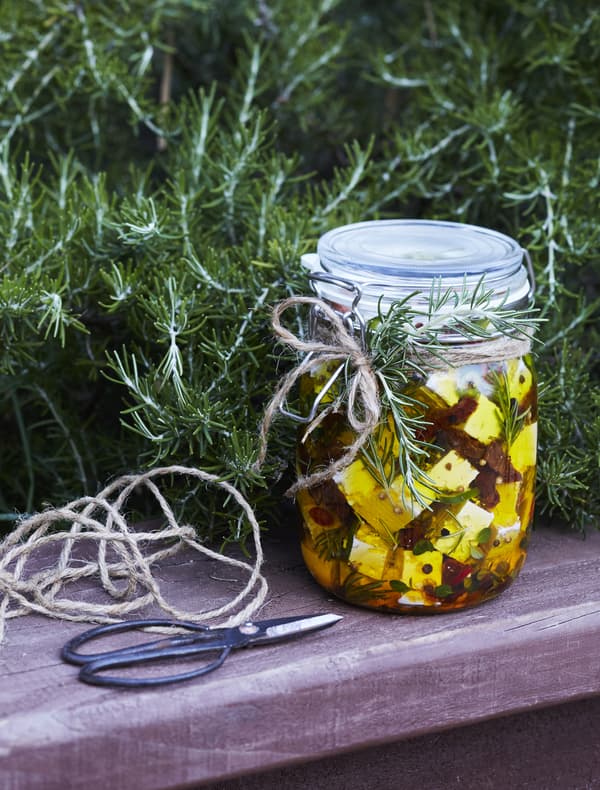 A jar of herbs and feta cheese