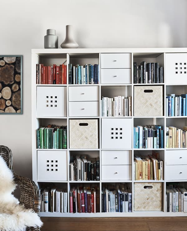 A KALLAX unit with storage boxes in some alcoves.