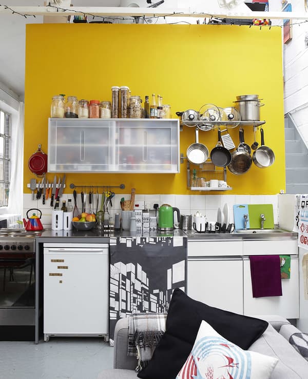 A kitchen against a yellow wall.