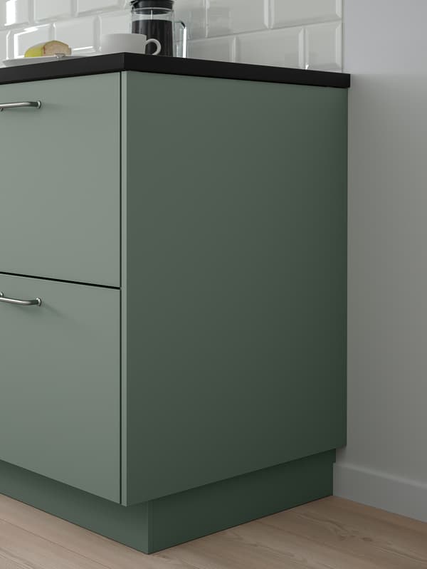 A kitchen cabinet with two grey-green drawer fronts and a grey-green cover panel.