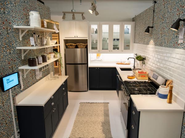 A kitchen display featuring a dark kitchen cabinet front with white countertops and lighting above.