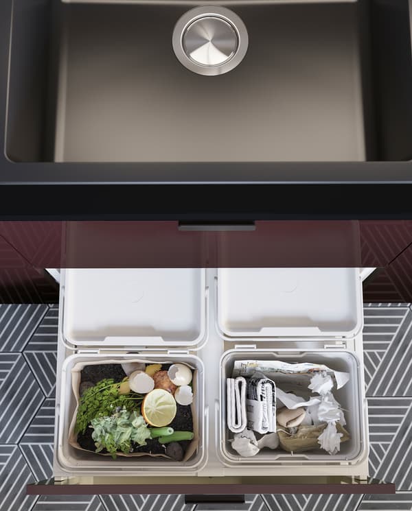 A kitchen drawer is open and inside is a light grey HÅLLBAR waste sorting solution with food waste and paper recycling.