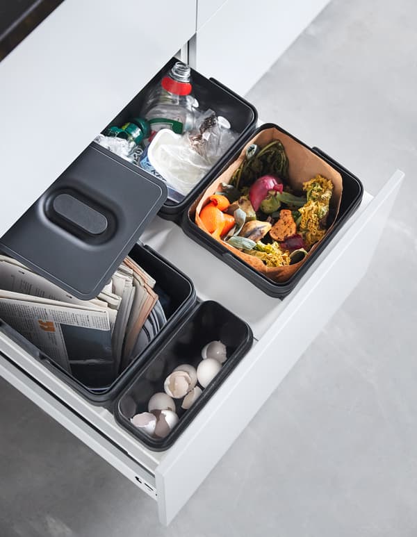 A kitchen drawer, with e.g. VARIERA/UTRUSTA waste sorting for cabinets; in a container there is paper and compost