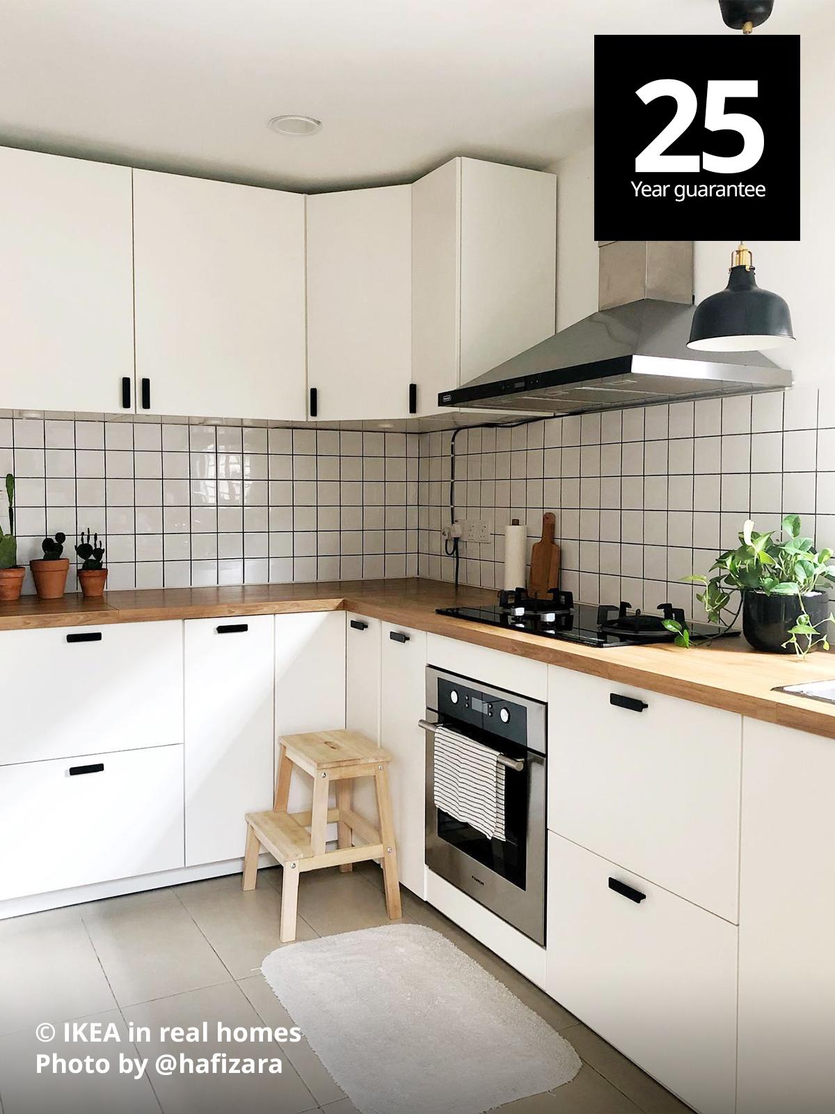 A kitchen setting - Featuring a BEKVAM step stool in front of a METOD kitchen with oak effect countertop and white METOD cabinets customise to @hafizara. Photo by instagrammer @hafizara IKEA in real homes ©