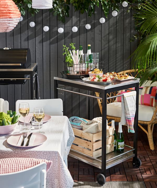 A kitchen trolley with food and glasses.