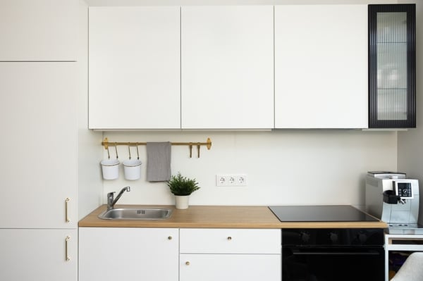 A kitchen view with white wall and base units, a built-in oven, and a wooden worktop.