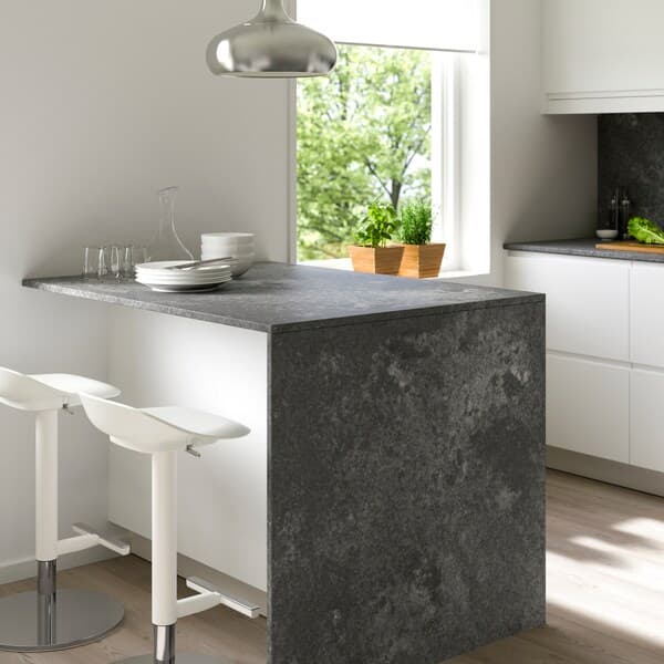 A kitchen with a grey ceramic worktop in focus.