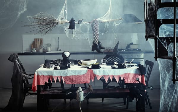 A kitchen with a large table that is full of Halloween decorations.