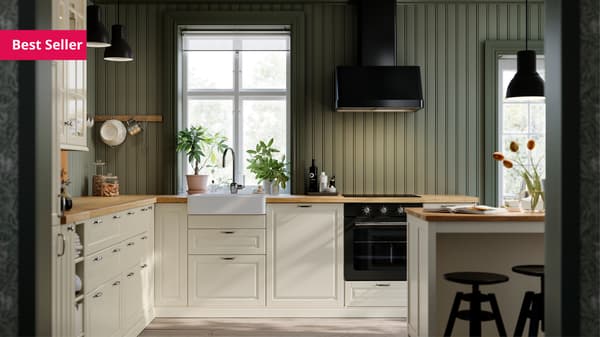 A kitchen with BODBYN doors and drawer fronts in off-white, and a FOKUSERA wall-mounted extractor hood in black.