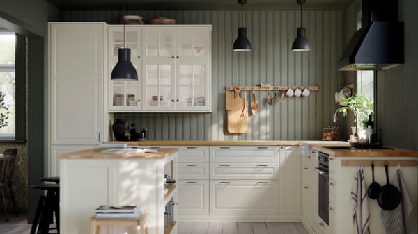 A kitchen with BODBYN drawer fronts and doors in off-white, HEKTAR pendant lamps and a MATTRADITION forced air oven.