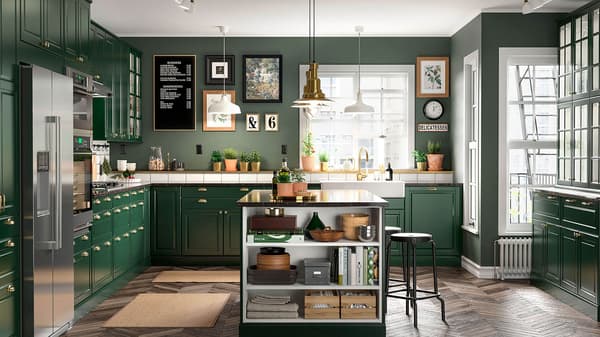 A kitchen with green cabinet doors and stainless appliances, with an island in the middle of the room.