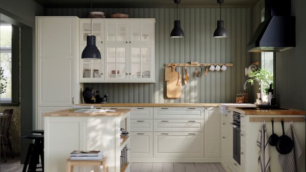 A kitchen with IKEA white cabinets, wooden countertops, an island, and natural light.
