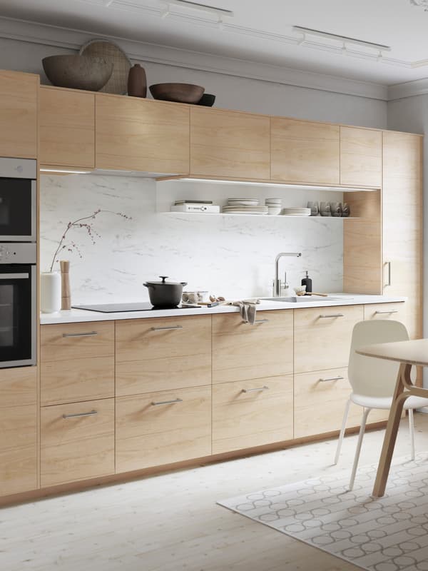 A kitchen with lighting under the top cupboards.